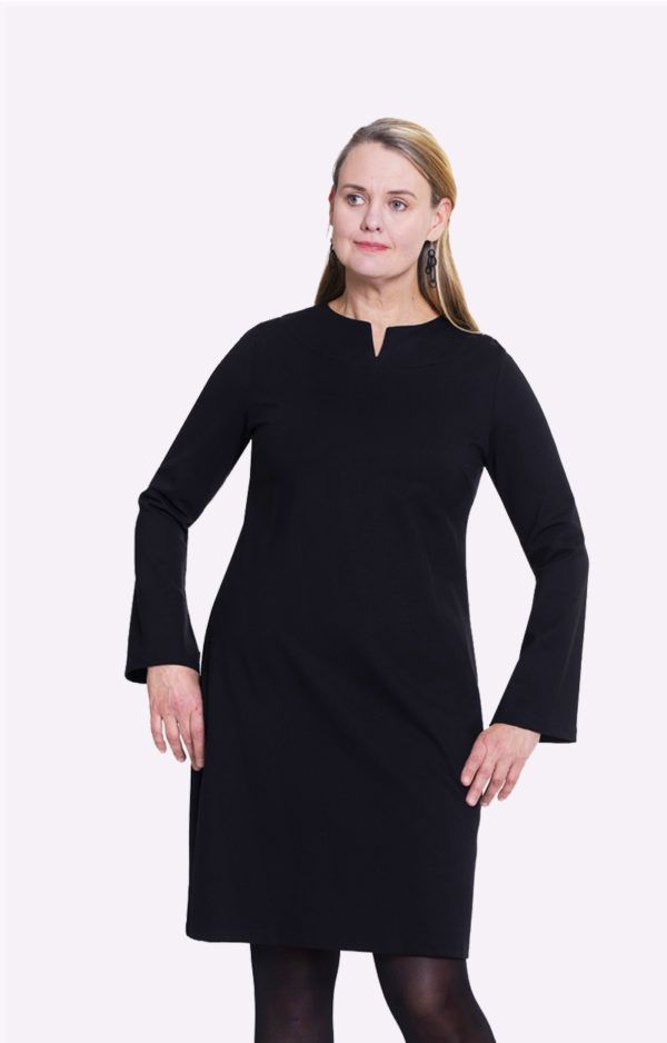 Kuvassa on malli, jolla on päällään musta ELSA-mekko. Mekko on malliltaan kotelomekkomainen ja siinä on pääntiessä yksityiskohtana pieni halkio.